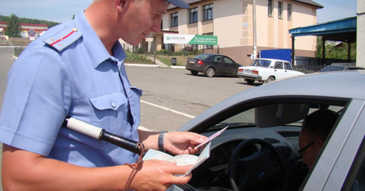полицейский проверяет документы у водителя